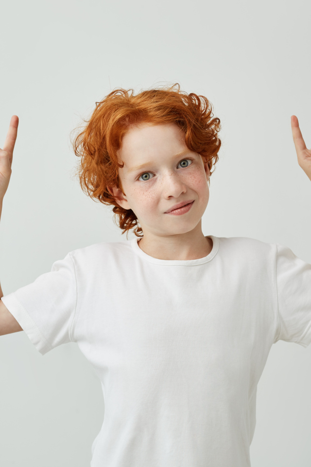 Рыжеволосый мальчик в белой футболке