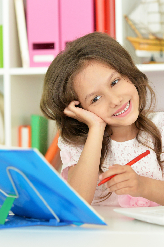 Улыбающаяся школьница делает уроки