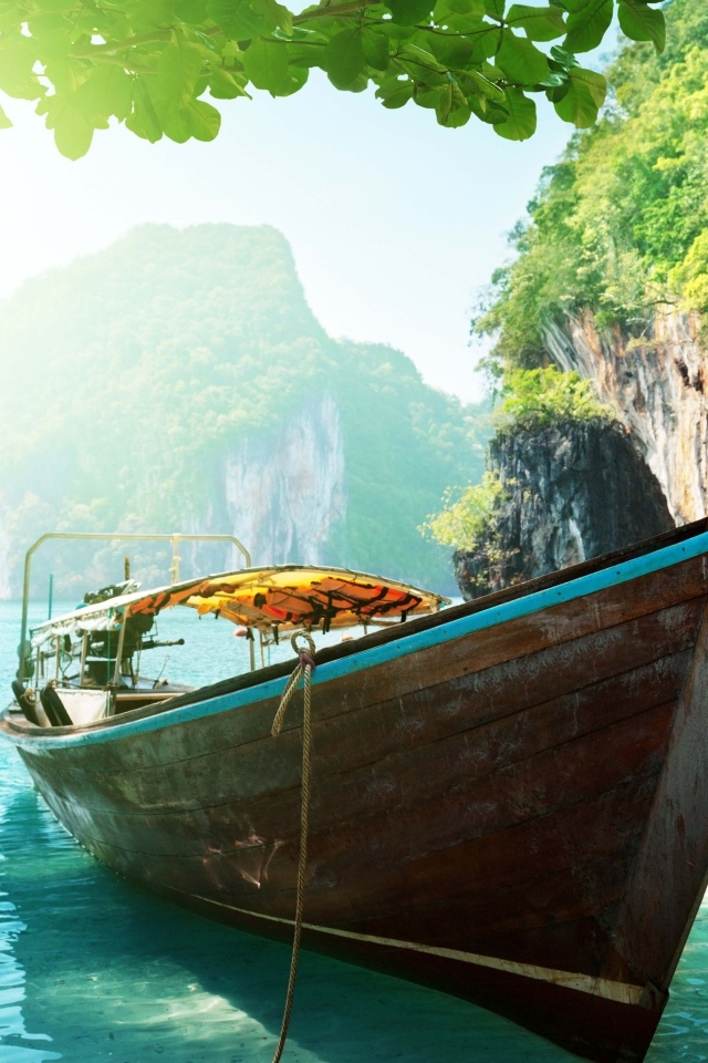 Деревянная рыбацкая лодка в воде на тропическом пляже