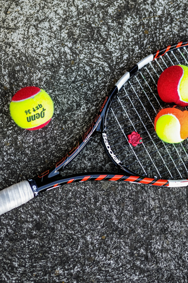 Ракетка и теннисные мячи на черном фоне