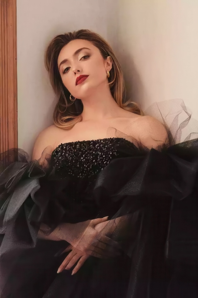 Актриса Пейтон Рой Лист в черном платье стоит у стены