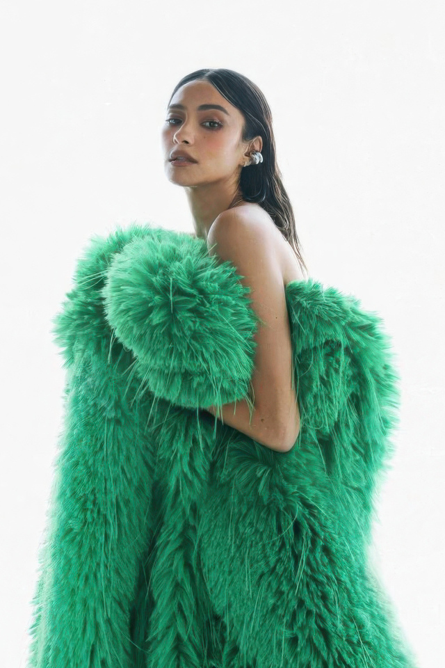 Актриса Шэй Митчелл в зеленой шубе на белом фоне