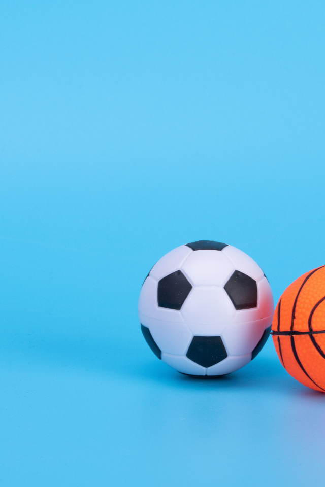 Футбольный и баскетбольный мяч на голубом фоне