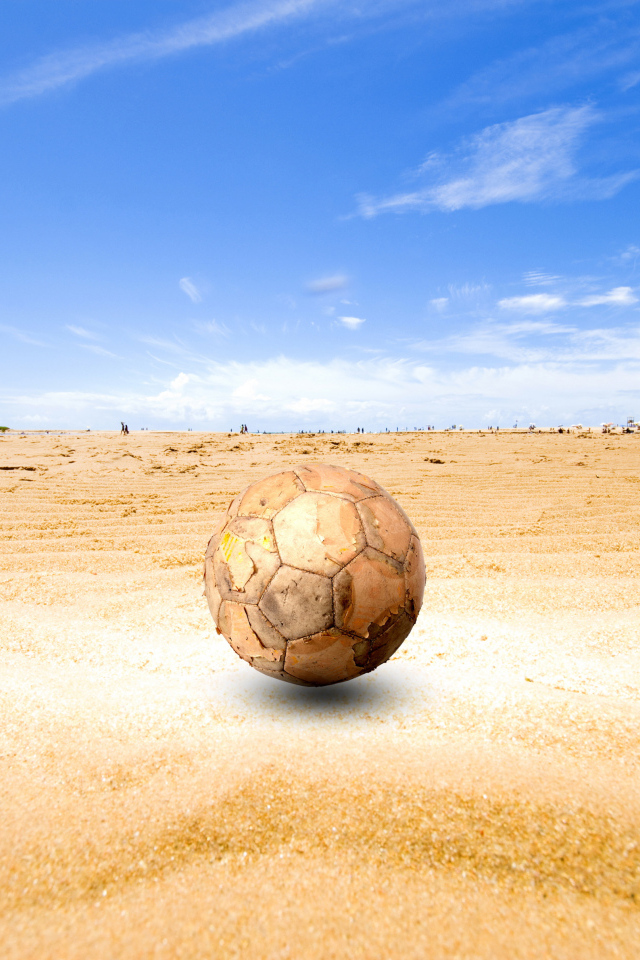 Старый футбольный мяч на песке