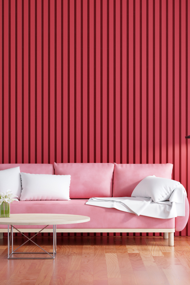 Розовый диван на фоне красной стены