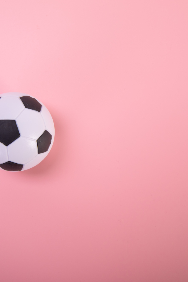 Футбольный мяч на розовом фоне