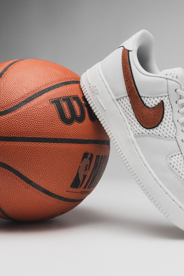 Спортивная обувь и баскетбольный мяч на сером фоне