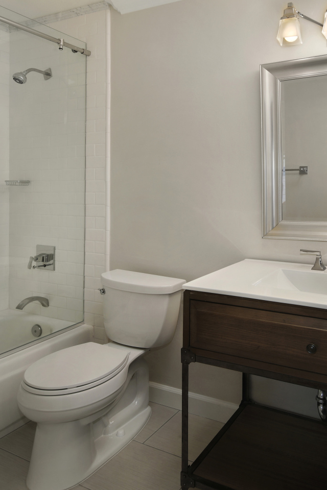 Интерьер ванной комнаты в белом цвете с душевой кабиной и унитазом