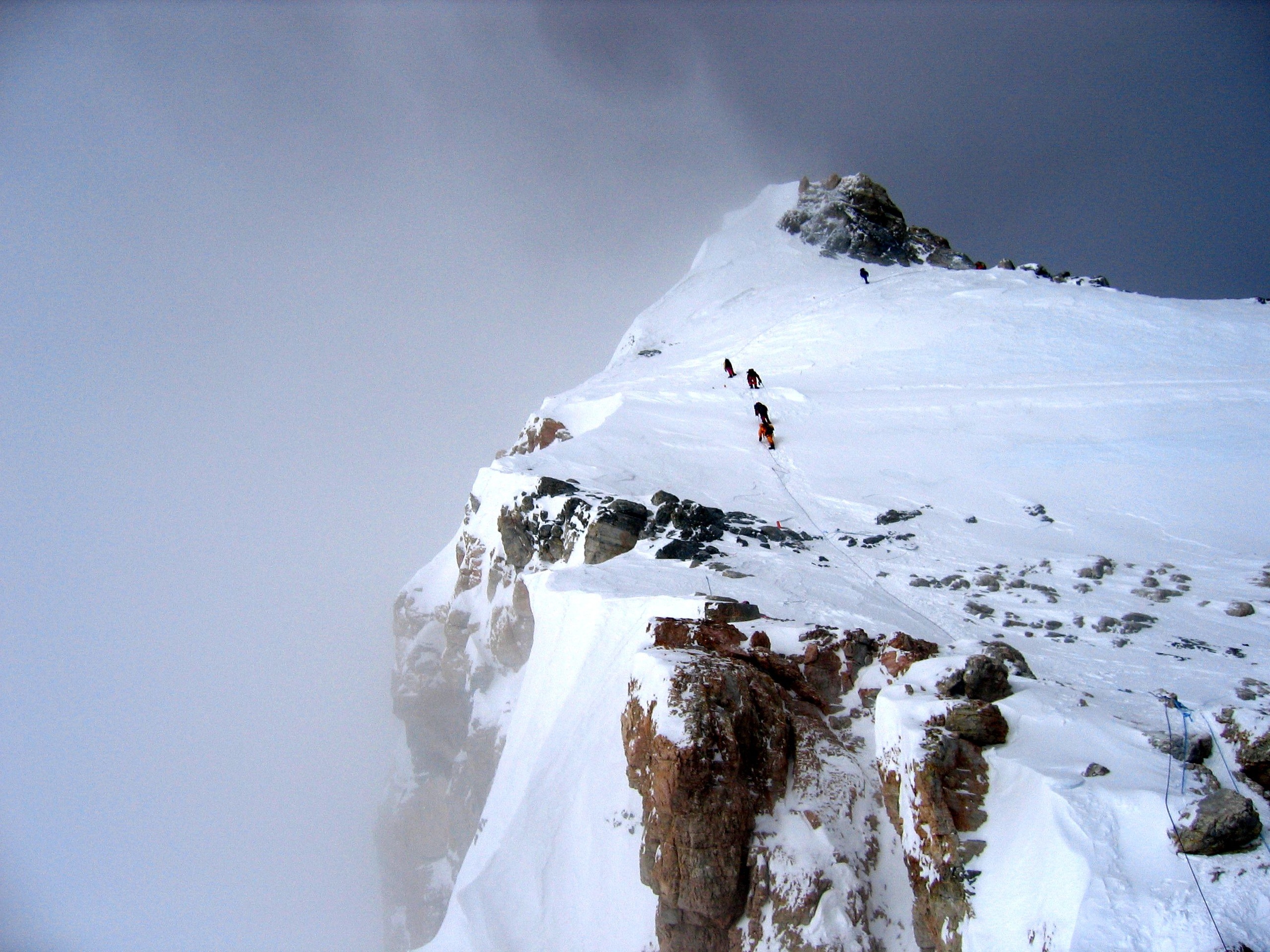 Облако разрастаясь вверх промчалось по склону горы. Френсис Арсеньева Эверест. Снежный склон. Вершина горы. Горы со снегом на вершине.