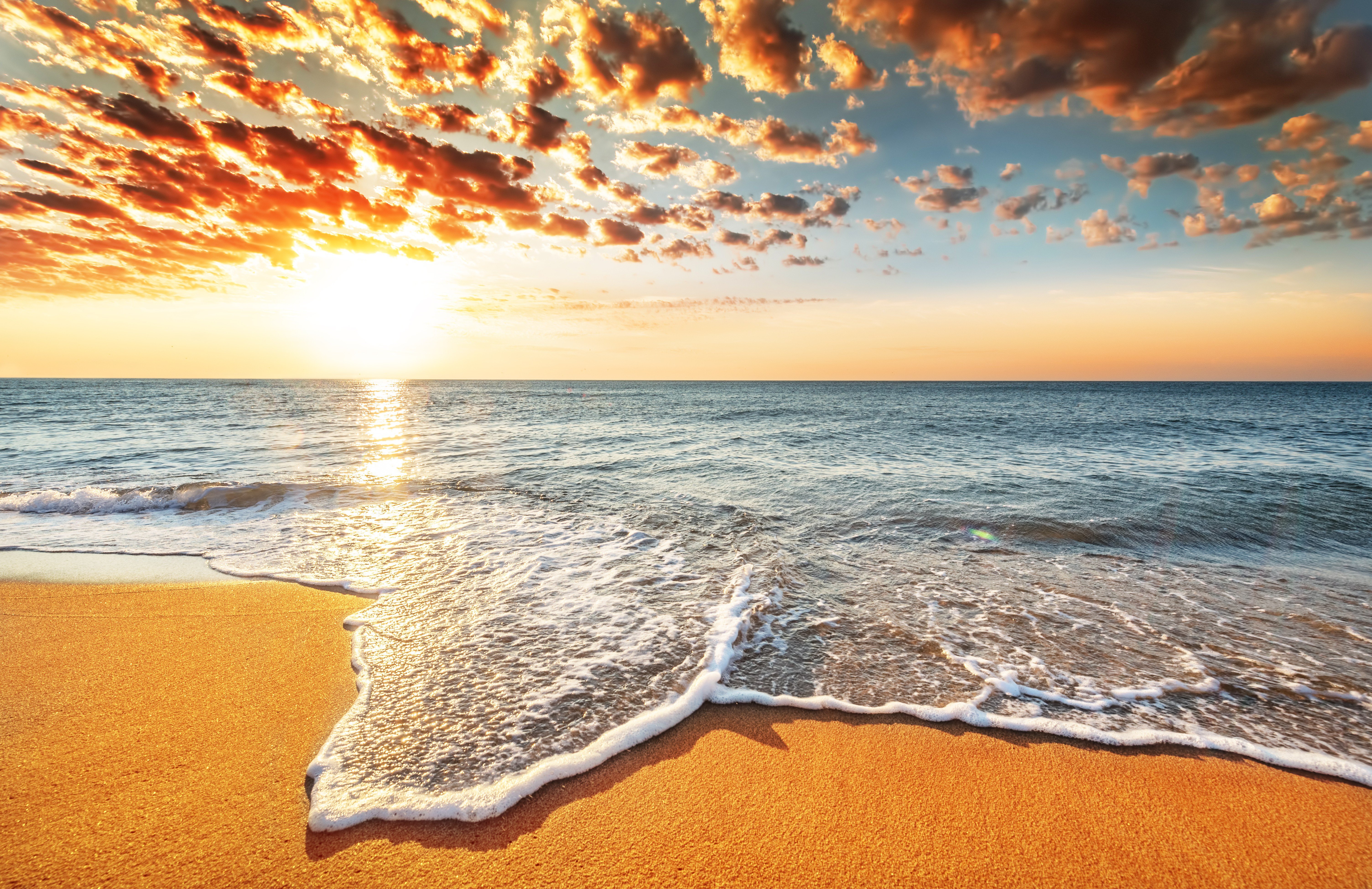Zastaki.com - Морская волна омывает песок на берегу под красивым небом