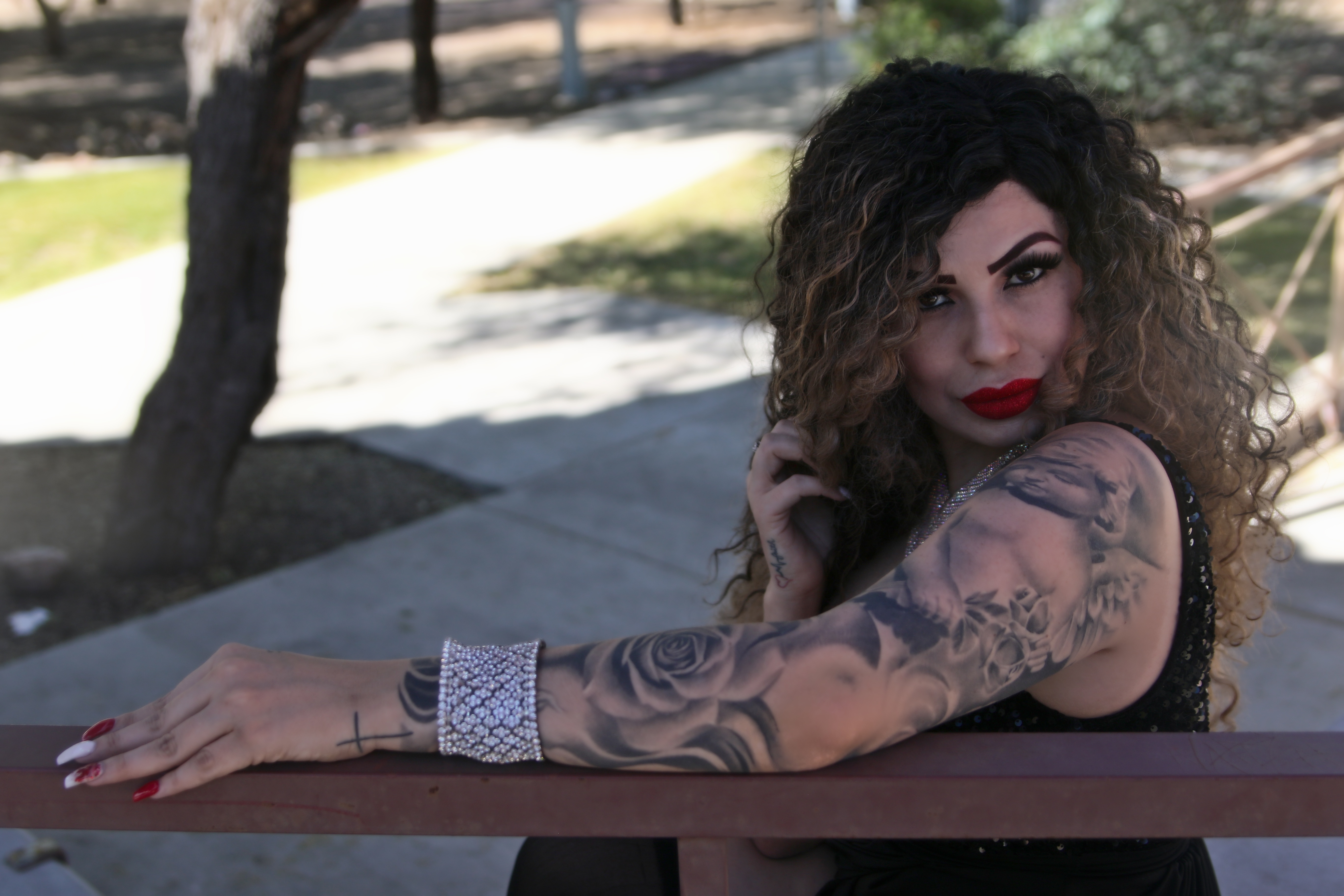 Zastaki.com - Красивая девушка с татуировками на руках сидит на лавке 