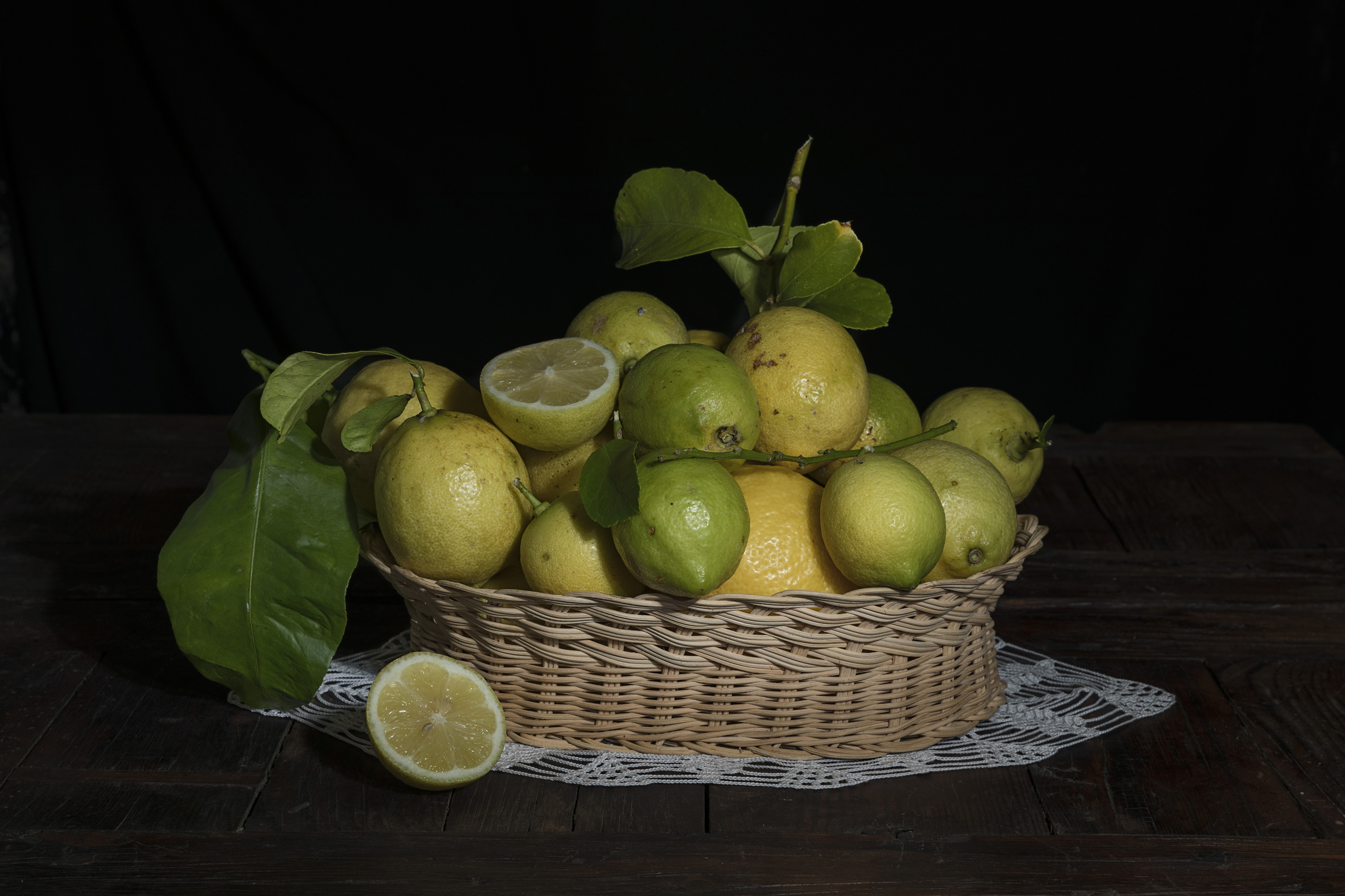 Zastaki.com - Лимоны и лаймы в плетеной корзинке на черном фоне