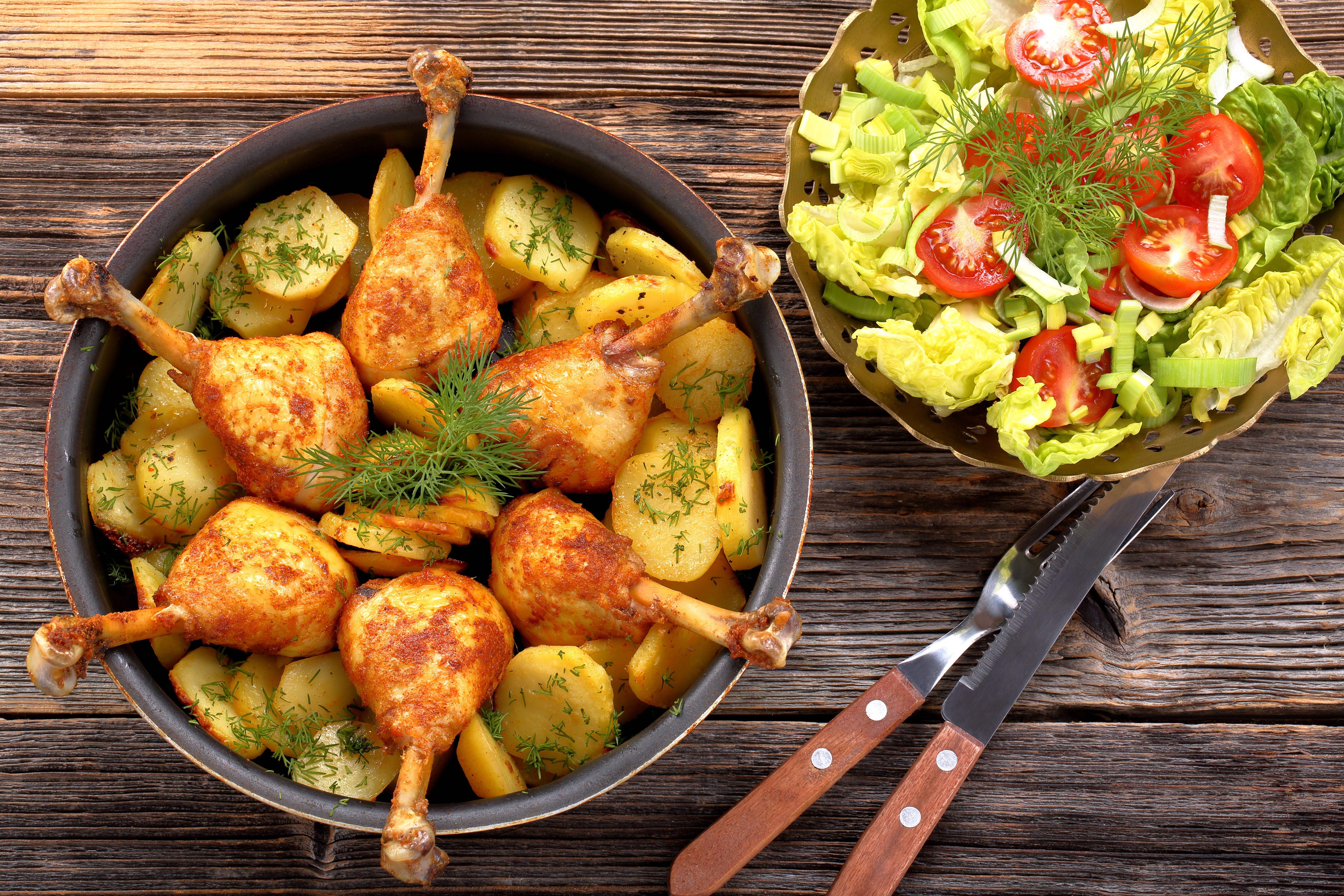 Zastaki.com - Жареные куриные ножки с картофелем на столе с салатом 