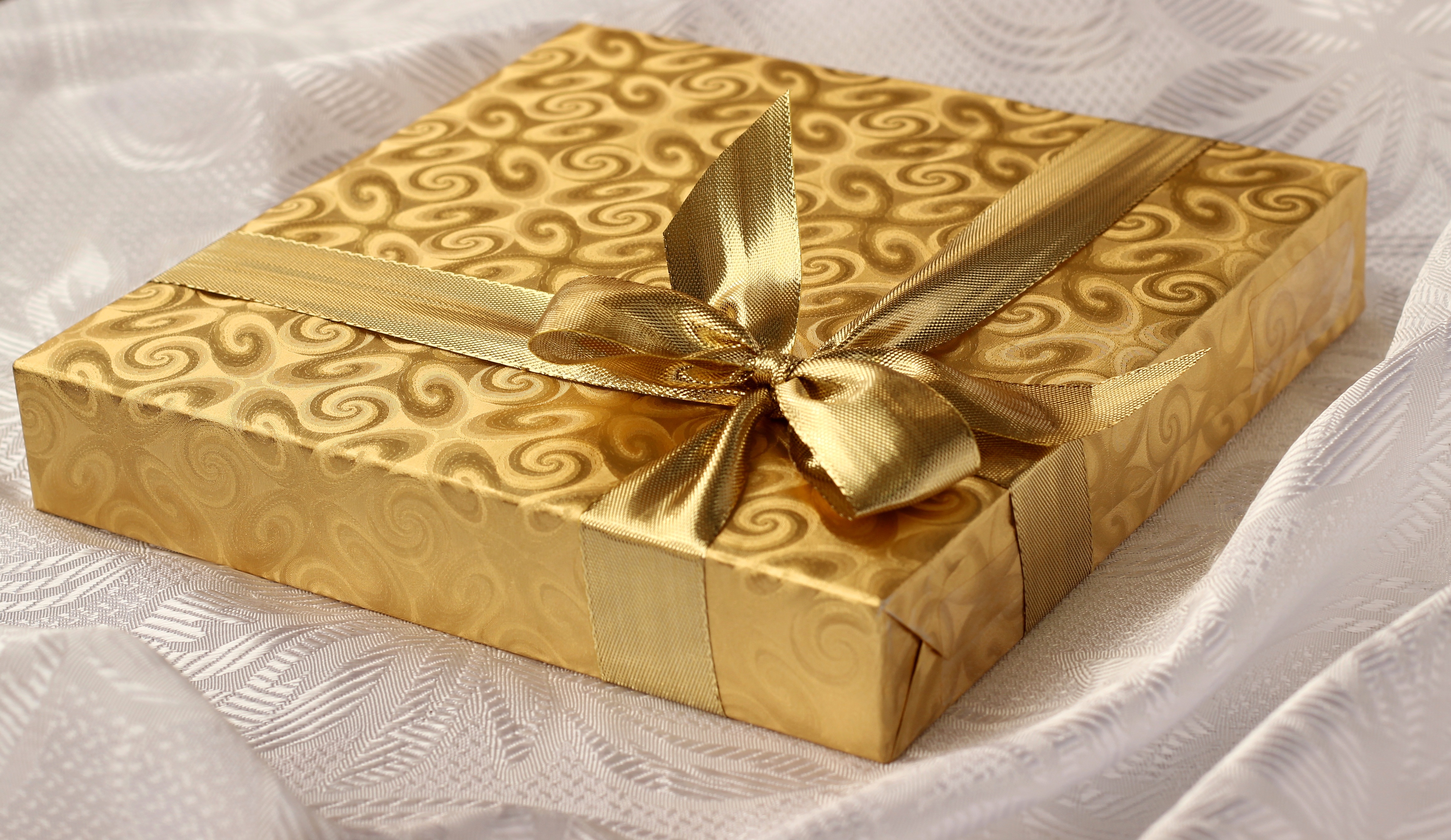 Zastaki.com - Красивая золотистая коробка с подарком на кровати 