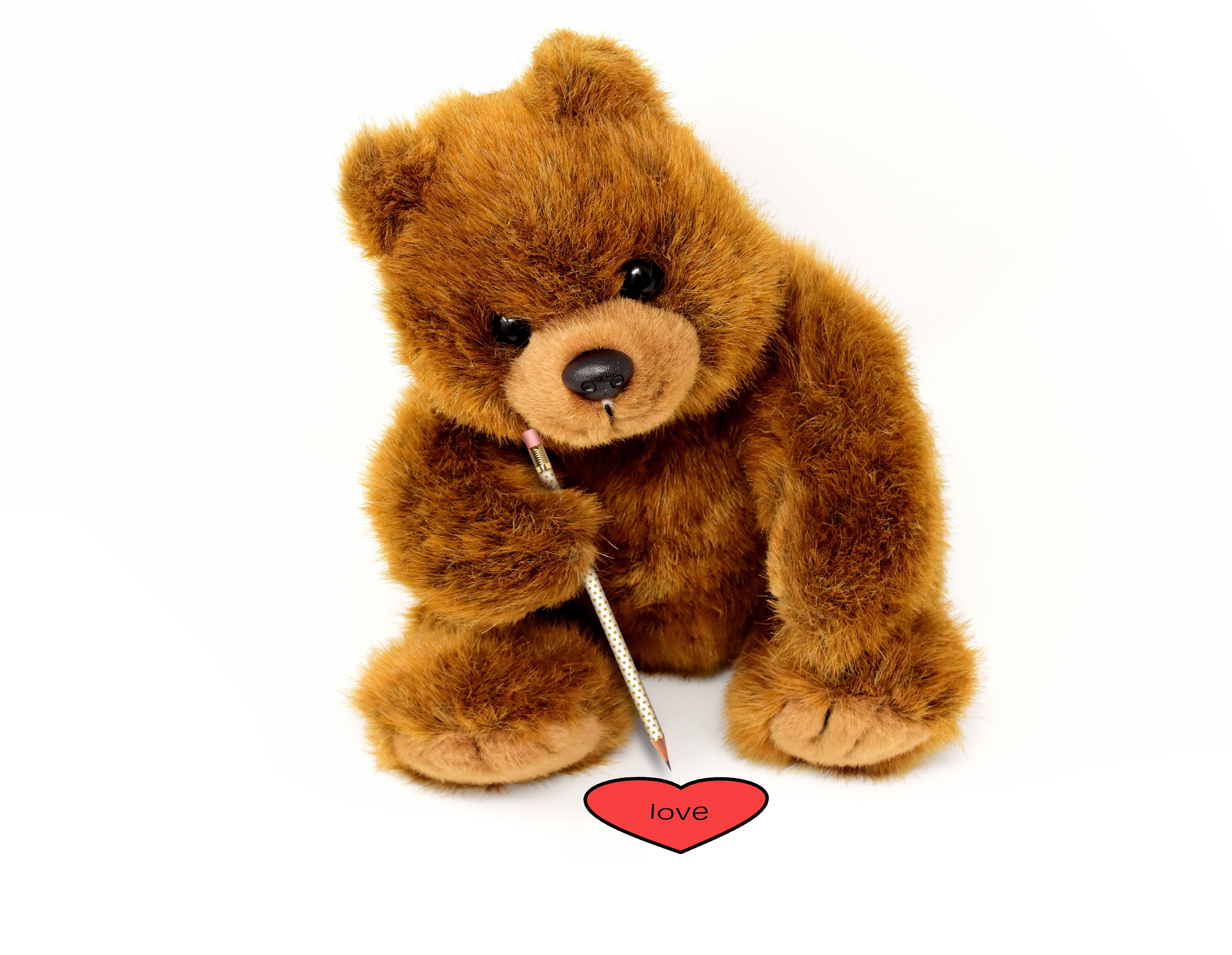 Zastaki.com - Игрушка медвежонок рисует сердце на белом фоне 