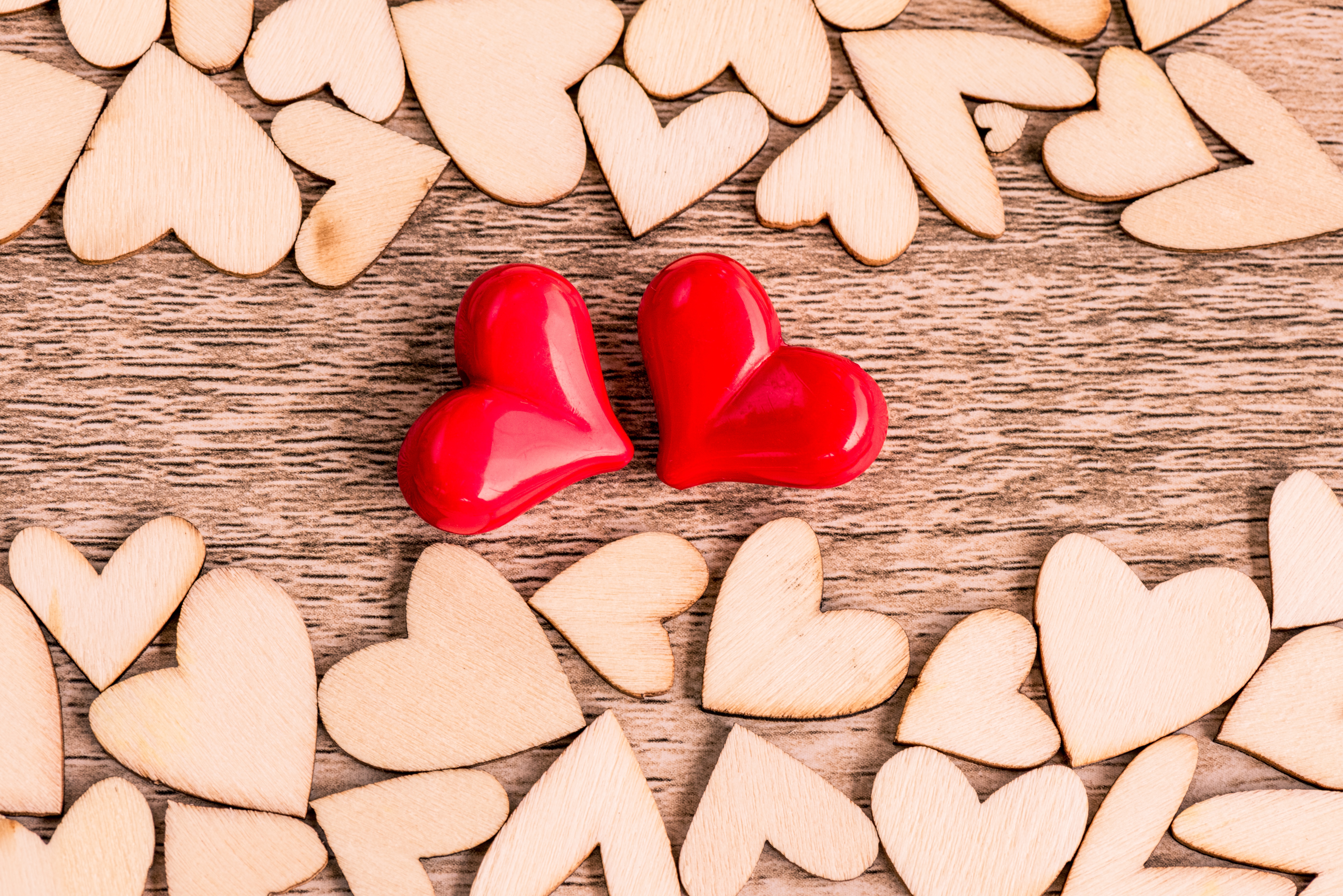 Zastaki.com - Два красных сердца и деревянные сердечки на столе