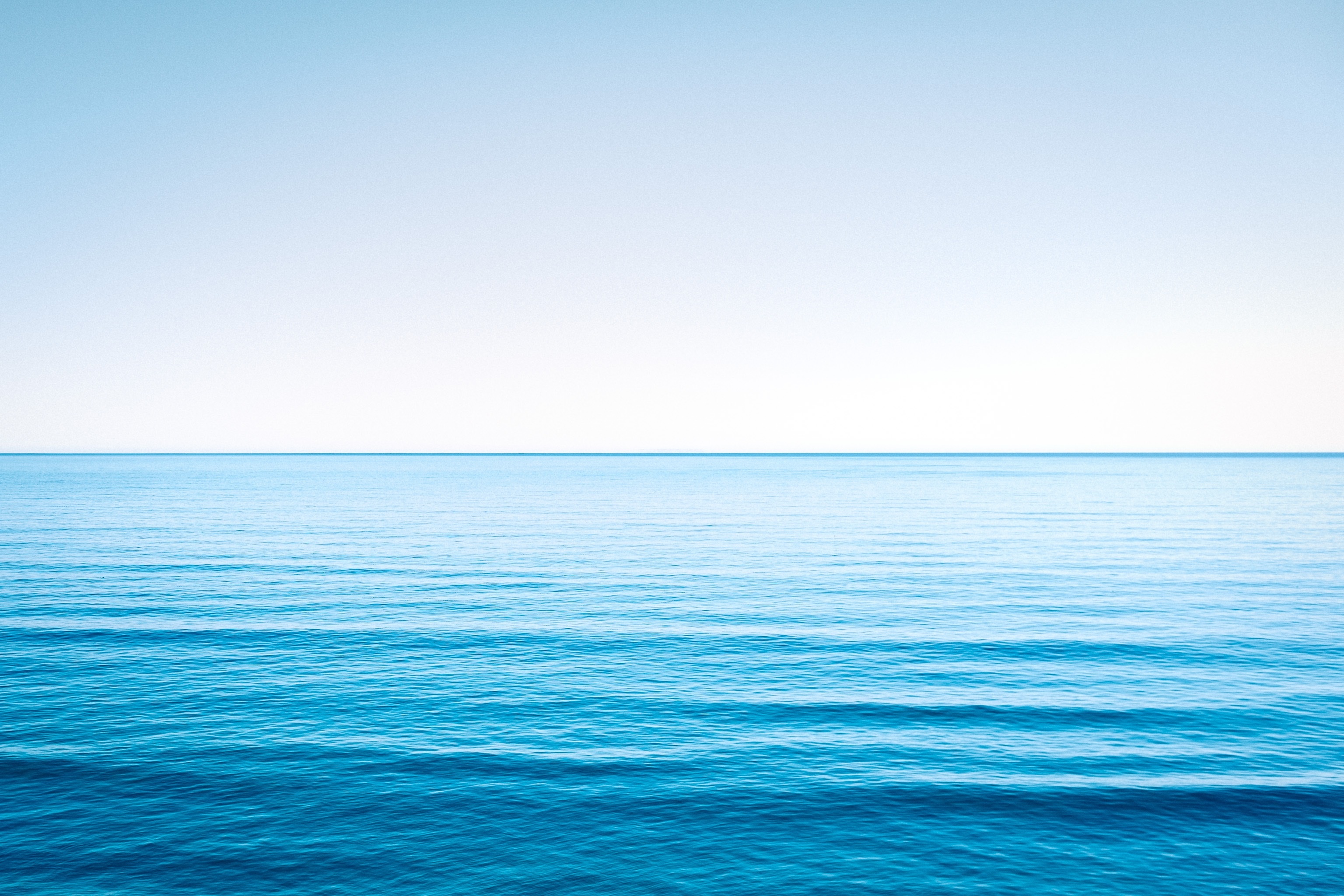 Спокойная голубая морская вода под голубым небом - обои для рабочего .